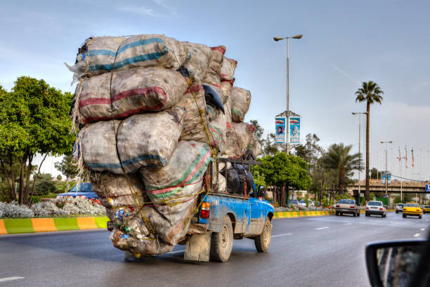 überladen mit taschen von abfällen, bewegt sich fahrzeug auf der autobahn, iran - überquellen stock-fotos und bilder