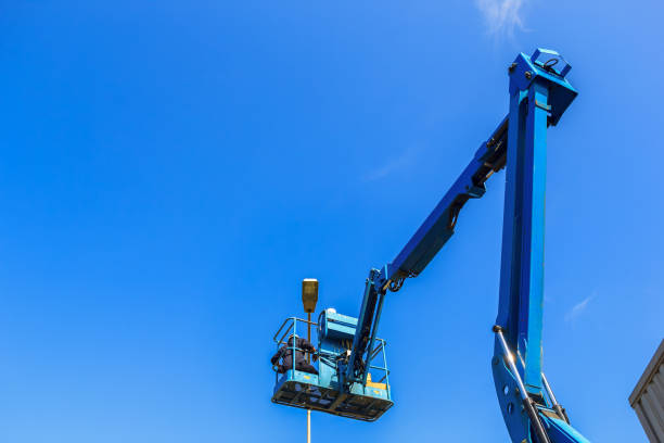istock Electrical technician repairing street light by boom lift 854960356