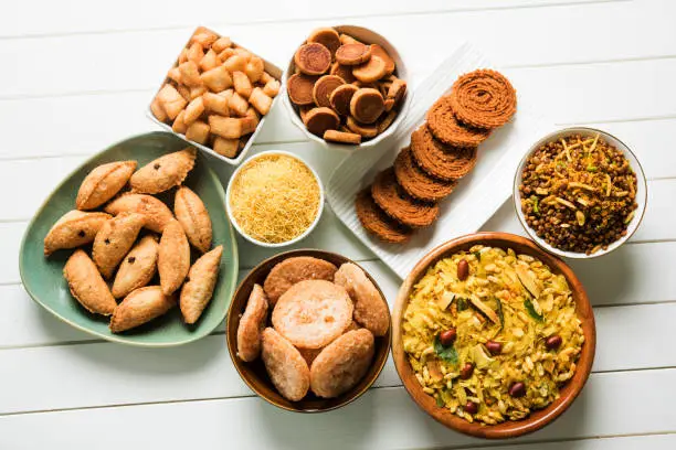 stock photo of  Diwali food or Diwali snacks or Diwali sweets like anarsa, bakarvadi, chakli, sev, bhujiya, shankar pale and chivda or chiwada, karanji, favourite indian diwali recipe, selective focus