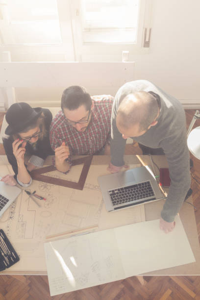istock Group of young people / architects being creative in a small office. 854965784
