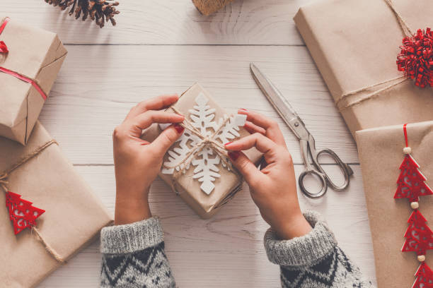 istock Woman's hands wrapping christmas holiday present with craft twine 854968630