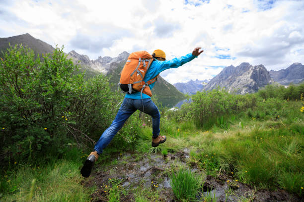 istock backpacking woman jumping in mountains 854968724