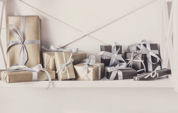 istock Holiday presents, gift boxes on white shelves at wall background 854969076