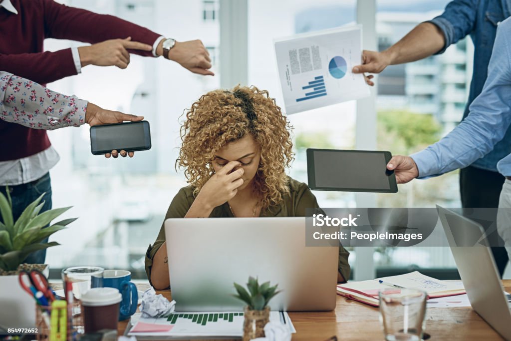 Work commitments are closing in on her Shot of a young businesswoman looking stressed out in a demanding office environment Emotional Stress Stock Photo