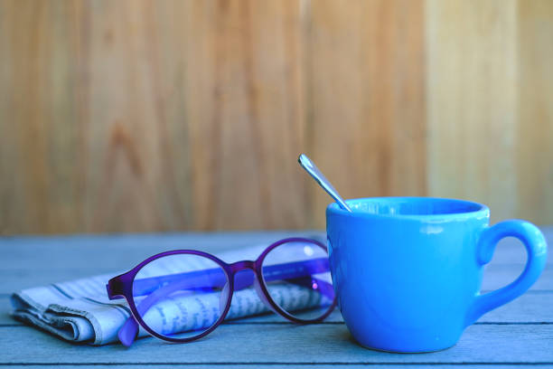 Close-up of coffee cup and drinking glass on table in office.