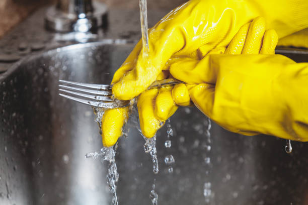 close up of female hand with sponge washing dish in the kitchen at home
