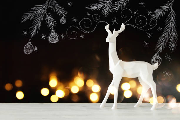 istock White reindeer on wooden table over chalkboard background whith hand drawn chalk illustrations. 854974058