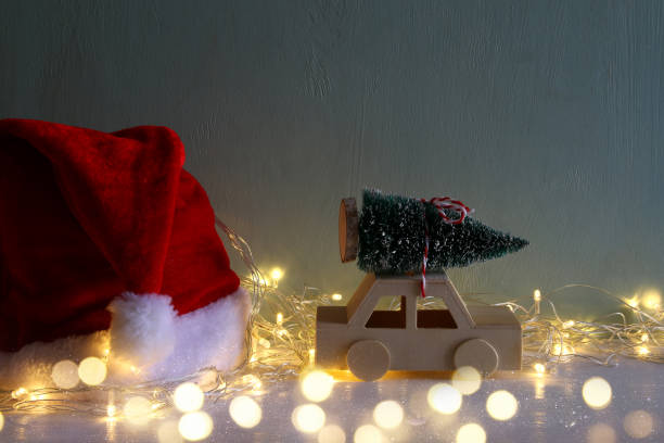 istock wooden car carrying a christmas tree next santa hat 854980270