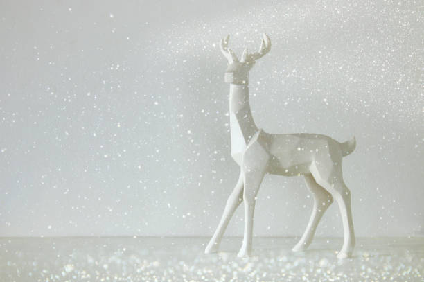 istock White reindeer on wooden table over white background 854980284