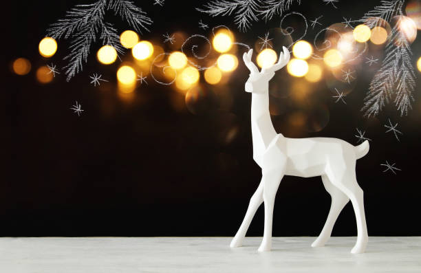 istock White reindeer on wooden table over chalkboard background whith hand drawn chalk illustrations 854980318