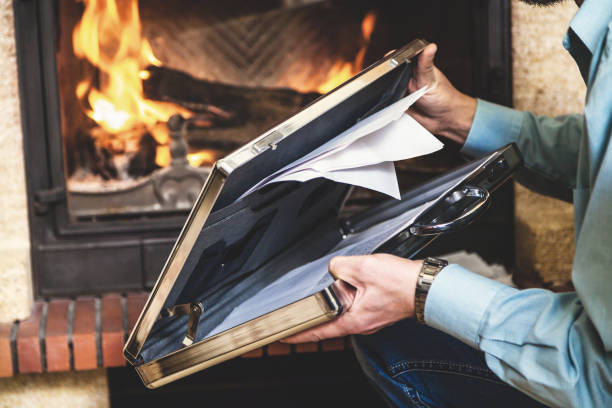 istock Steel case with documents in hands of businessman and fireplace 854981534