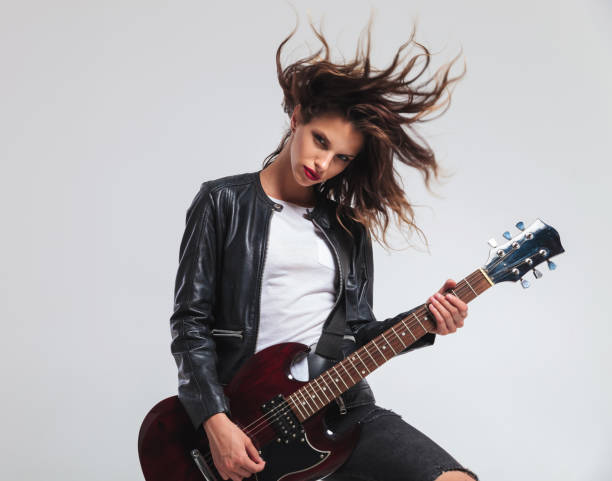 istock cool headbanging rock and roll woman playing electric guitar 854987812