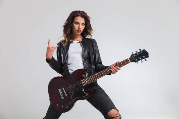 istock cool woman guitarist making a rock and roll hand sign 854988106