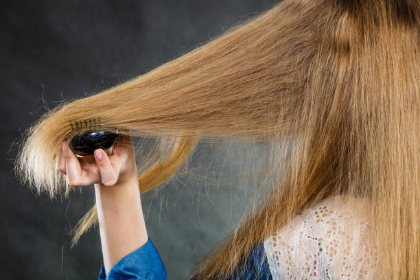 istock Blonde woman combing her hair. 854988188