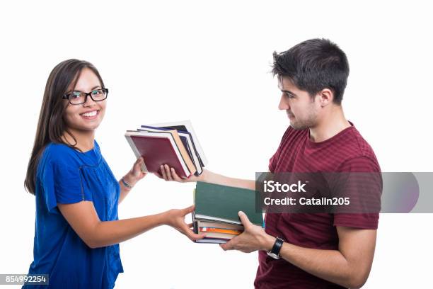 Handsome Student Couple Exchanging Bunch Of Books Stock Photo - Download Image Now - Book, Exchanging, Bookshelf