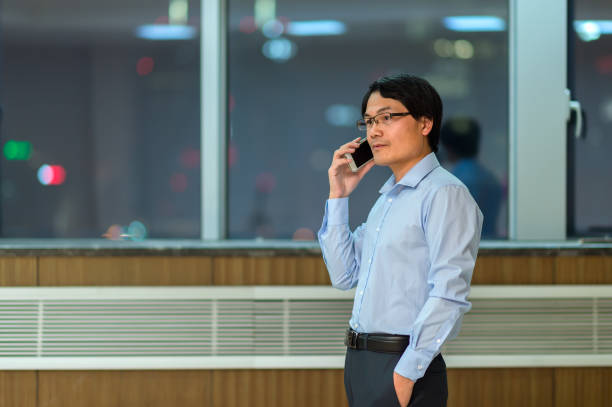 istock Businessman using smartphone in cityscape from office 854995564