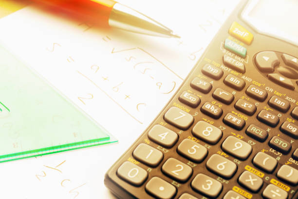 istock Overhead view of brightly lit calculator with math instruments 854995714
