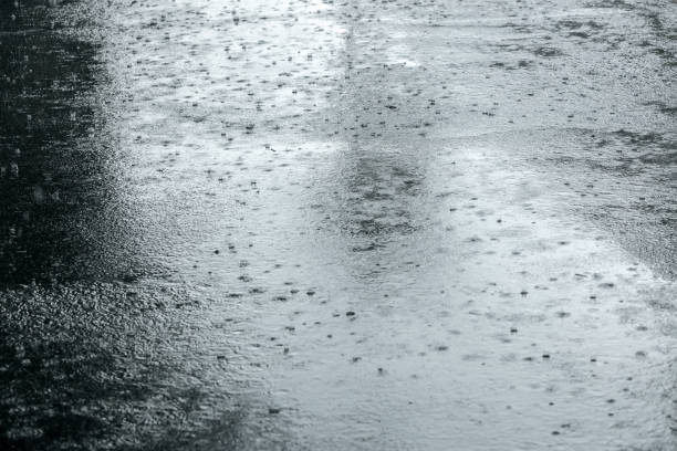 istock wet sidewalk with raindrops in puddles during heavy rain 854998906