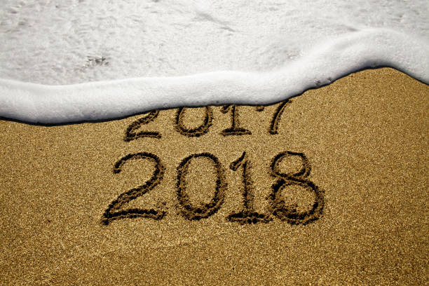 istock New year 2018 and 2017 on sandy beach with waves 854999716