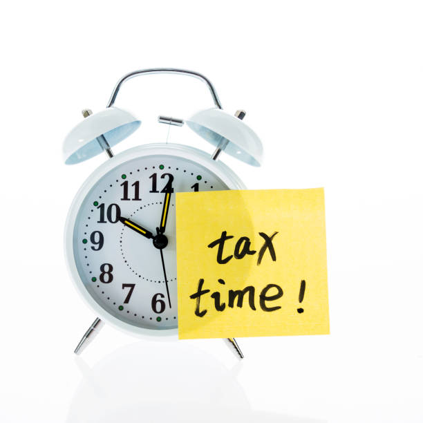 istock A clock with tax time sticky note on white background 854999870