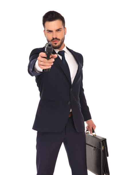 istock serious young hitman pointing and aiming his gun 855002916