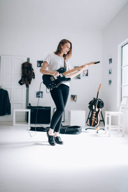 istock Beautiful woman playing electric guitar 855003908