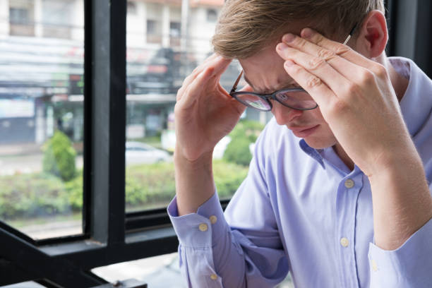 istock tired businessman with hand on forehead at office. frustrated man with headache at workplace. exhausted startup business owner in depression after long work. overwork, stress, fatigue concept 855004834