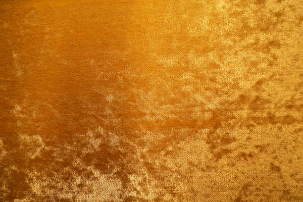 złoty kolor aksamitnej tekstury tła tkaniny - aksamit zdjęcia i obrazy z banku zdjęć