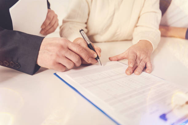 istock Pleasant elderly woman signing papers 855011112