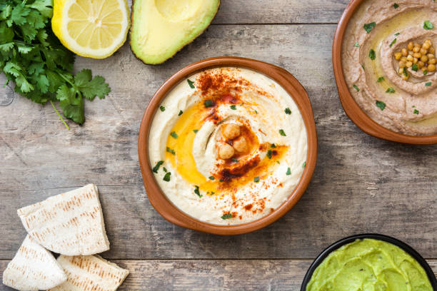 Different hummus bowls Different hummus bowls. Chickpea hummus, avocado hummus and lentils hummus on gray stone background hummus stock pictures, royalty-free photos & images