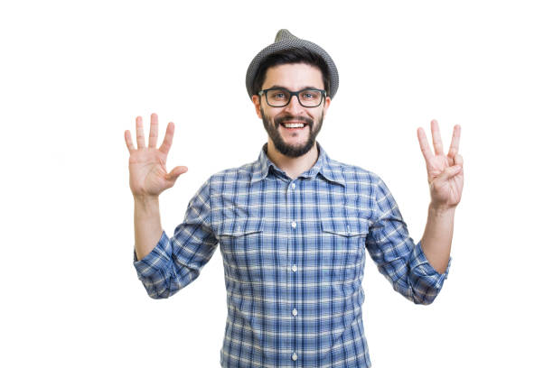 istock Handsome young guy in eyeglasses and hat showing eight on hand 855011404
