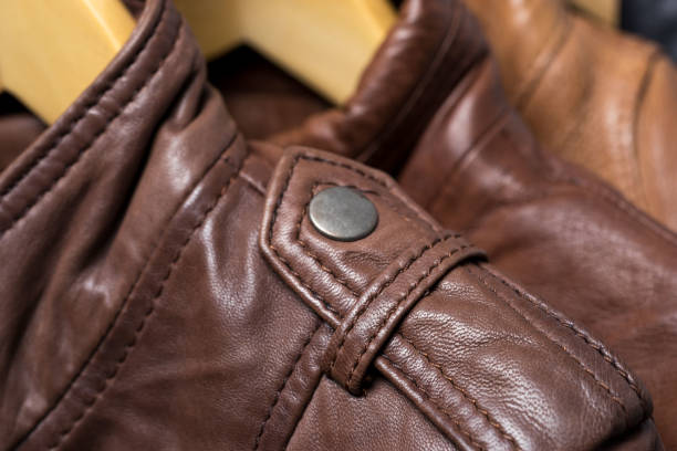 istock Brown leather jacket shoulder metal clasp button. Macro leather shoulder detail 855011944