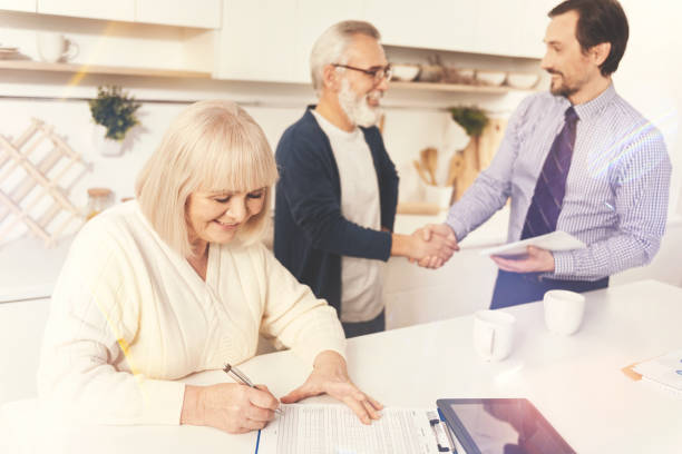 istock Cheerful aged woman signing papers 855014024