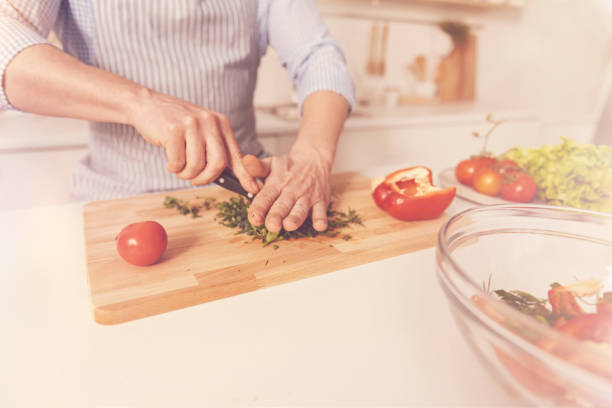 istock Pleasant man cooking salad in the kitchen 855018030