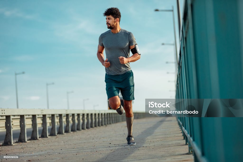 Confidence goes a long way Full length portrait of an african american athlete man running and listening to the music. Running Stock Photo