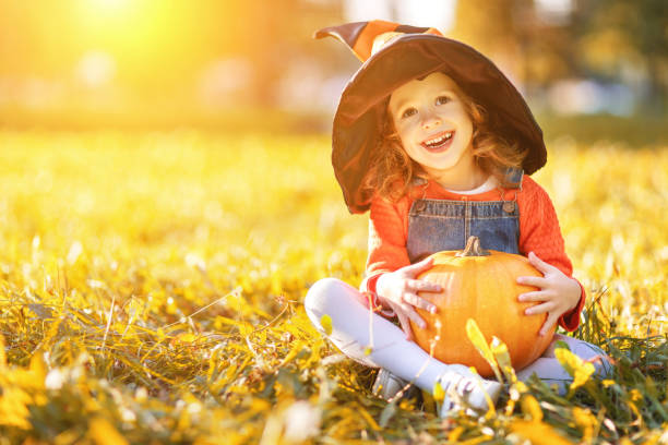 istock child girl with pumpkin outdoors in halloween 855026752