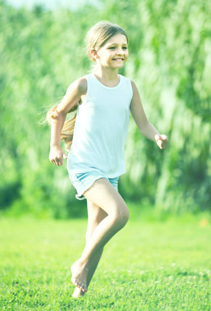 istock girl running and jumping on grass 855027450