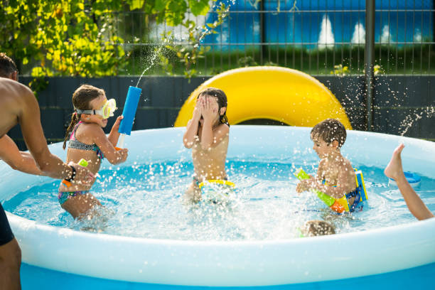 istock children having fun in pool at home in garden 855042328
