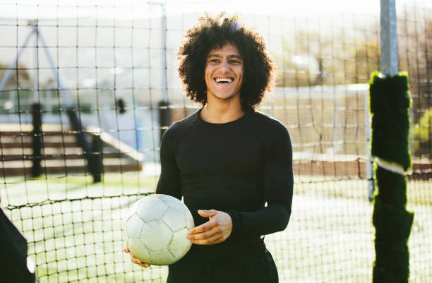 teenager-football-spieler lachend auf feld - soccer player soccer men smiling stock-fotos und bilder