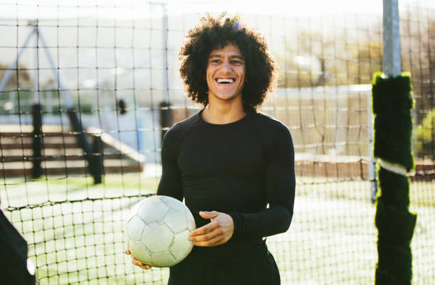 joueur de football chez les adolescentes en riant sur le champ - soccer player soccer men smiling photos et images de collection