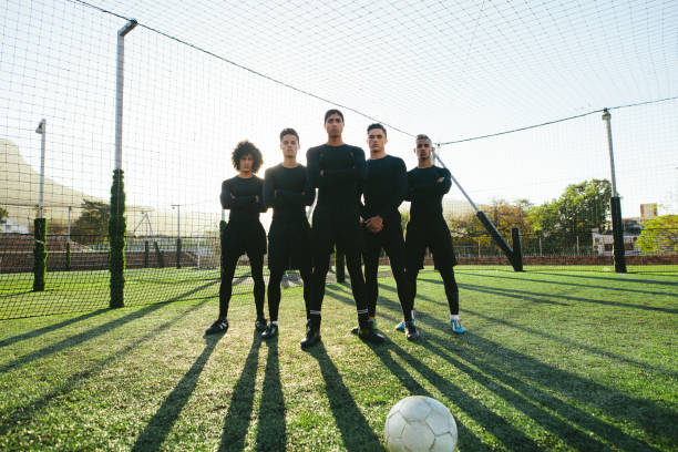 Soccer players standing together on pitch Full length of five a side football team on field during training. Soccer players standing together on football pitch. softball pitcher stock pictures, royalty-free photos & images