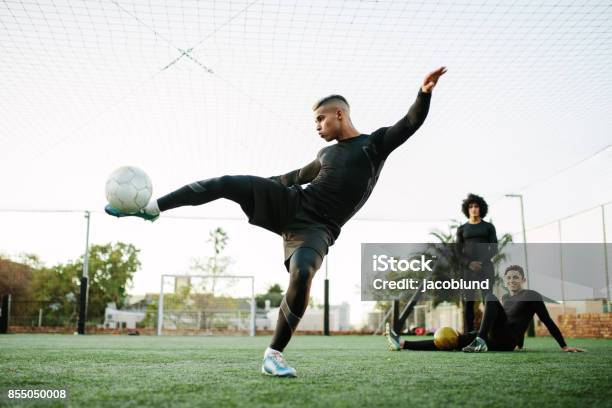 Player Kicking Soccer Ball On Field Stock Photo - Download Image Now - Soccer, Teenager, Soccer Ball