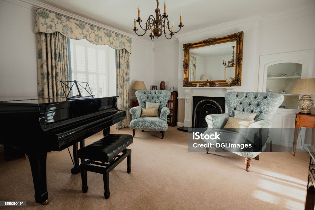Empty Music Room A traditional looking music room with armchairs and a grand piano. Tradition Stock Photo