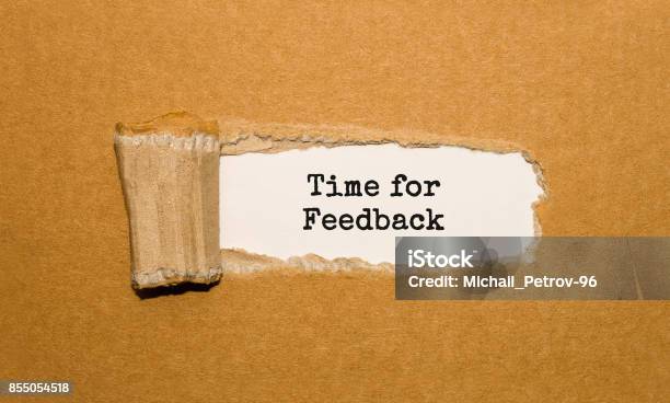 The Text Time For Feedback Appearing Behind Torn Brown Paper Stock Photo - Download Image Now