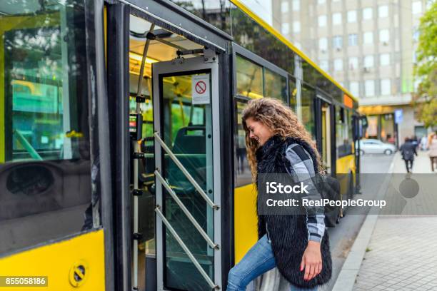 Young Woman Stepping Into The Bus Stock Photo - Download Image Now - Bus, City, Boarding