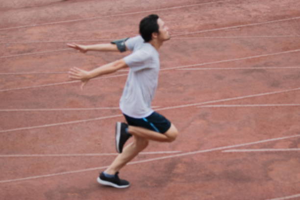 istock Abstract blurred of athletic handsome young Asian runner sprinter crossing the finish line on track in stadium. 855062882