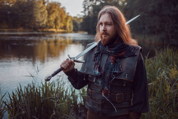istock Knight in the forest. A guy in medieval costume with a sword 855063346