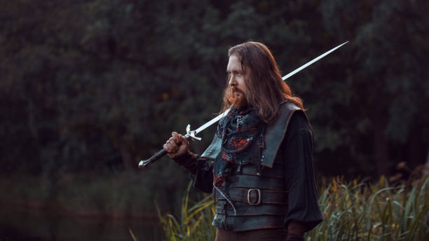 istock Knight in the forest. A guy in medieval costume with a sword 855063352