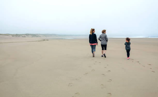 istock Three generations female walking on the beach 855069514