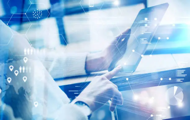 Photo of Concept of virtual screen,digital connection icon and graph interfaces.Young businesswoman using modern mobile tablet while sitting at sunny office.Blurred background.